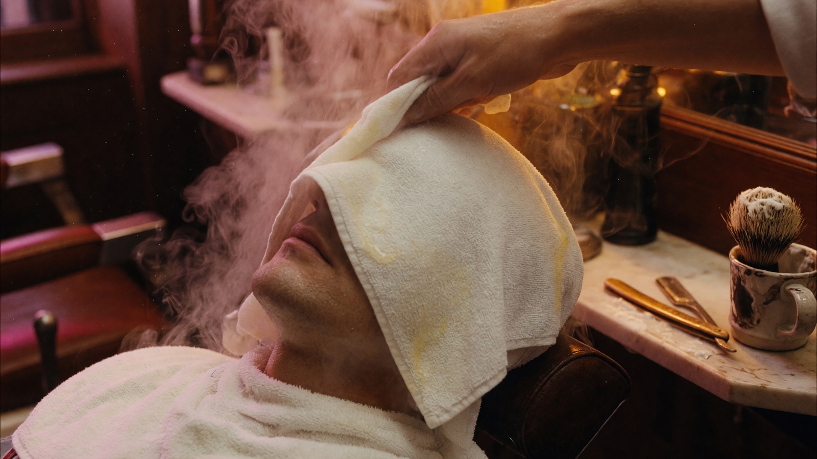 A steaming hot towel applied to a man's face during a hot towel shave at The Twisted Willow Barbershop