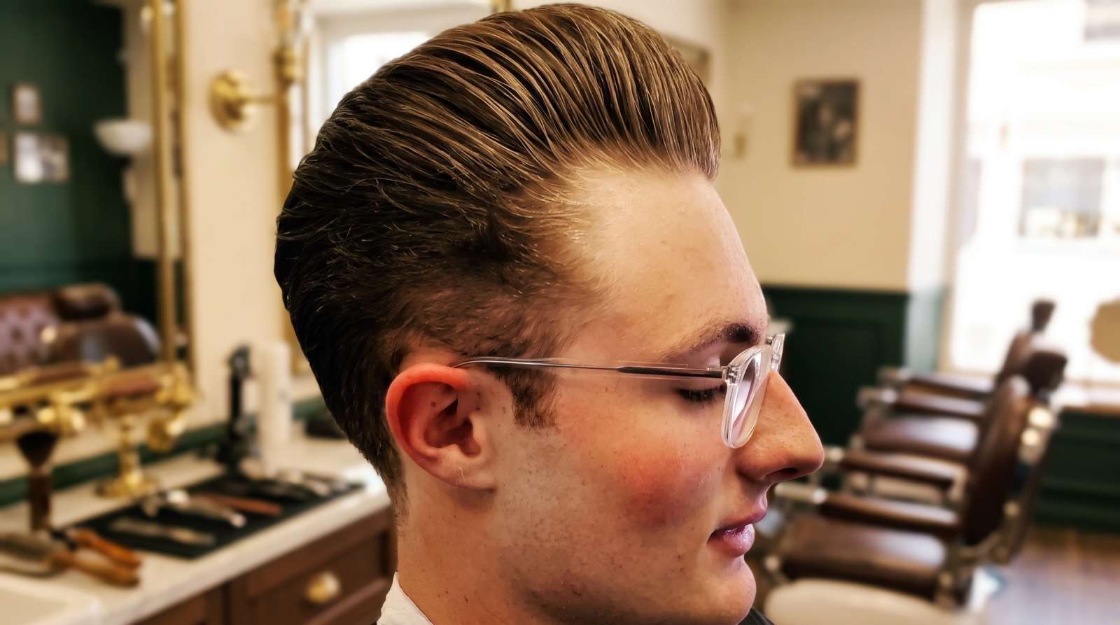 A man with a sharp fresh haircut and clean neckline in the barber chair at The Twisted Willow Barbershop in Berea, KY